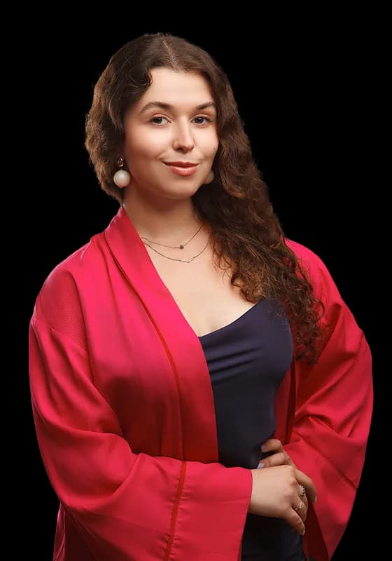 A teacher with long curly hair in a crimson kimono over a navy dress.